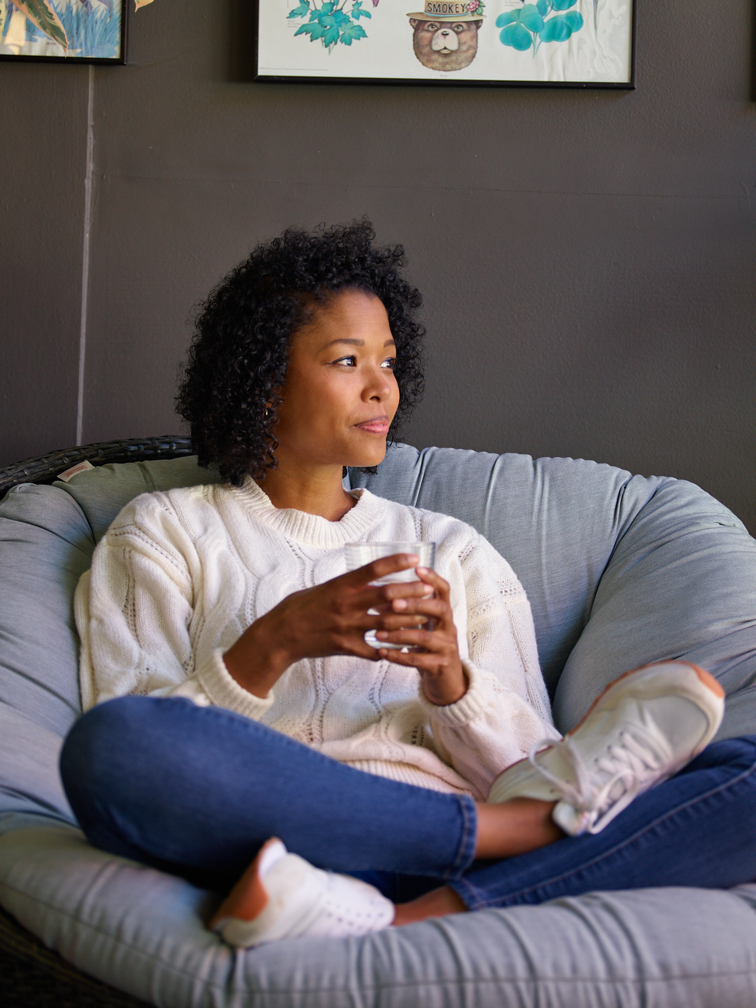 Image of a woman sitting on a couch in thought