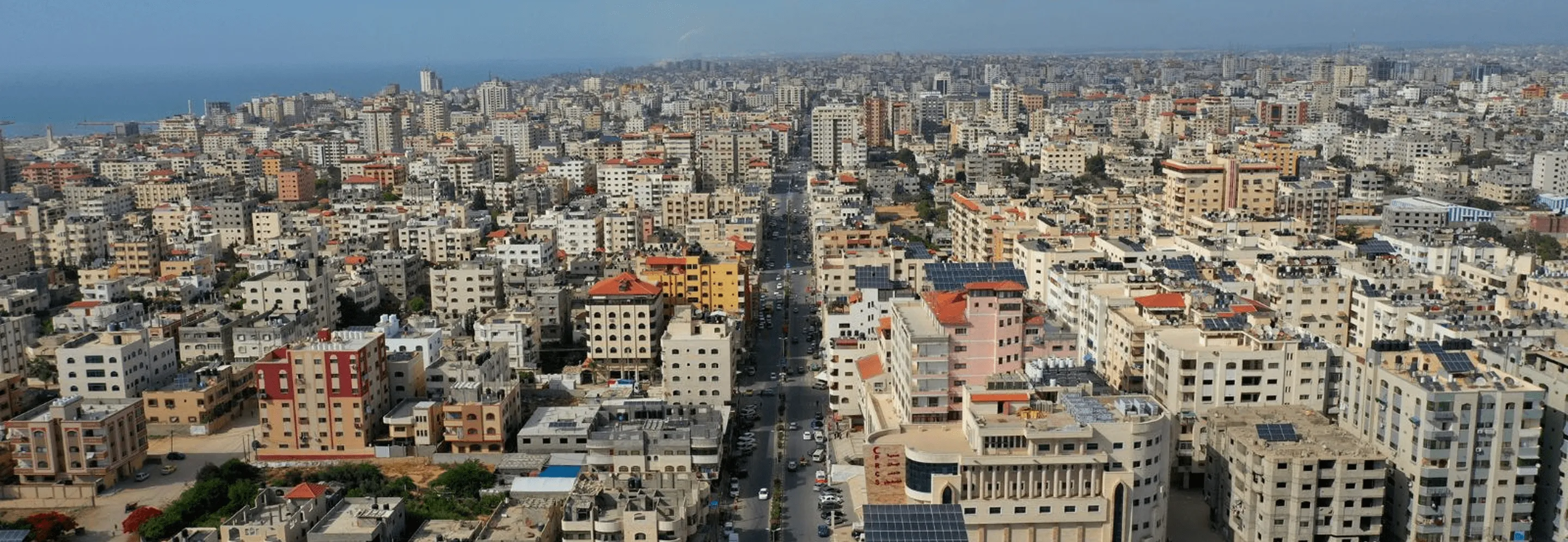 Aerial view of Gaza City, densely packed buildings stretching to Mediterranean Sea
