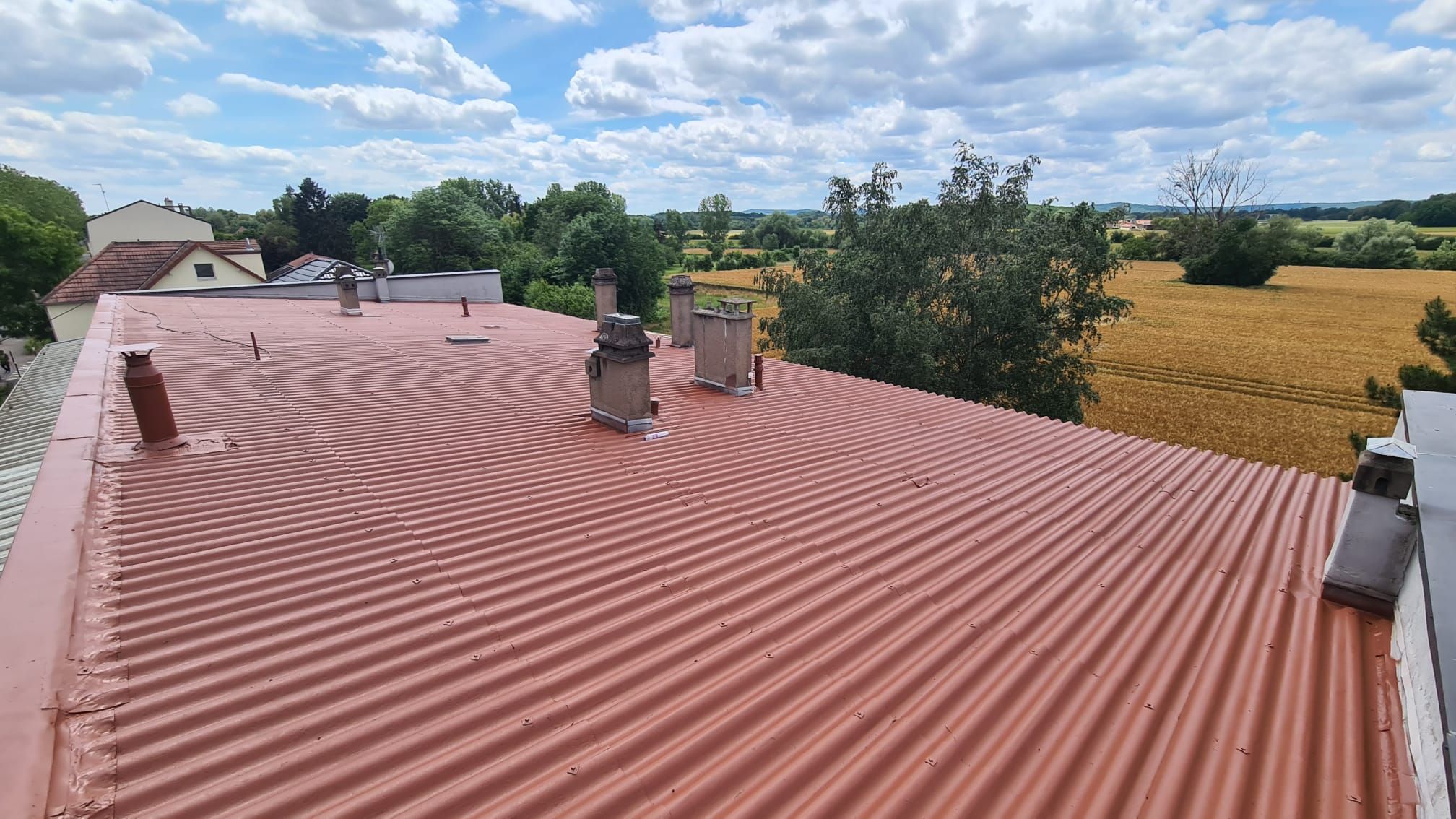 Toit rénové, rouge brique uniforme, sans mousse ni traces, météo claire.