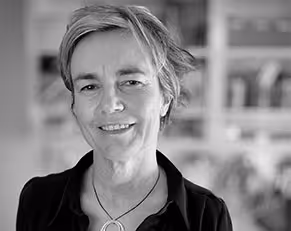 Black and white bio pic of Clare Brew smiling, looking at the camera.