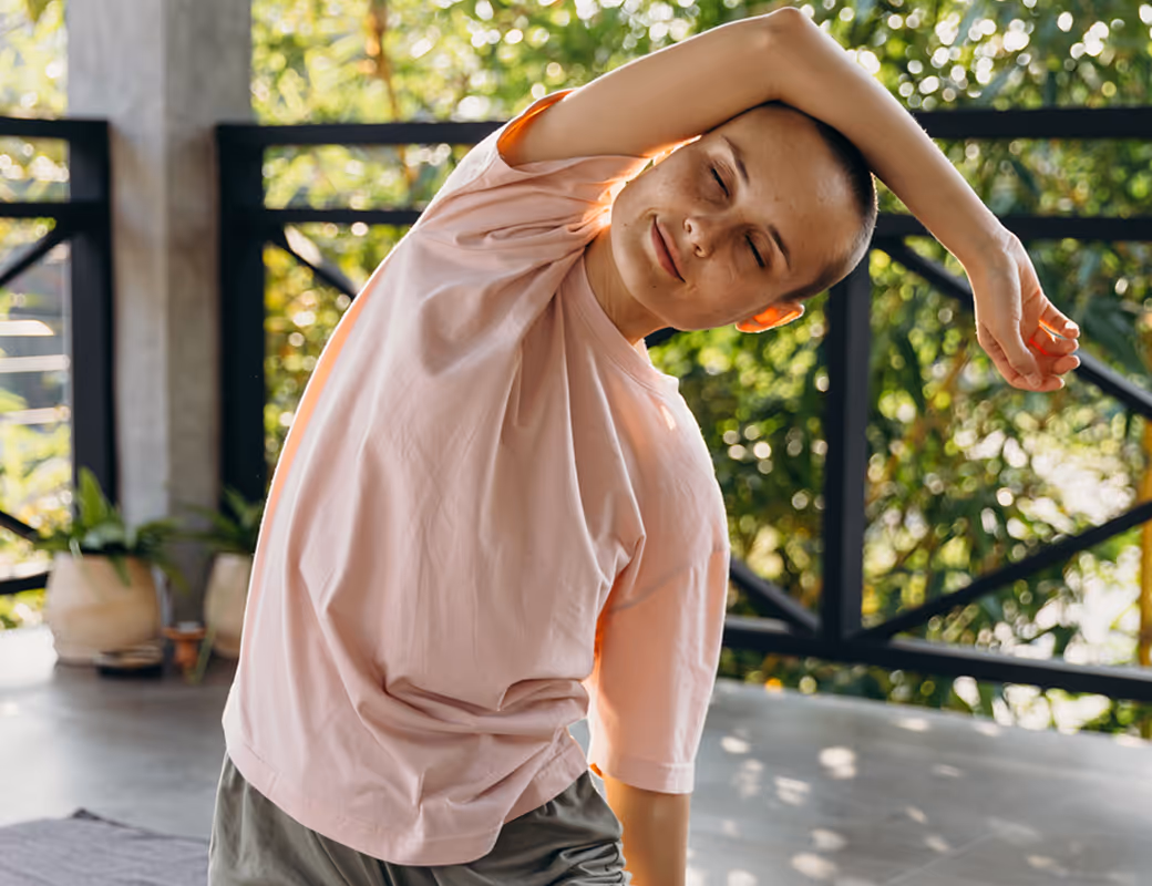 Young woman stretching with eyes closed during a peaceful indoor yoga session.