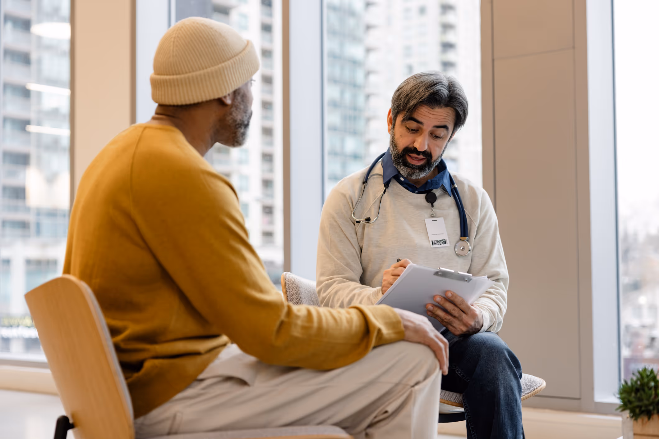 Doctor consulting with male patient in a modern clinic setting.