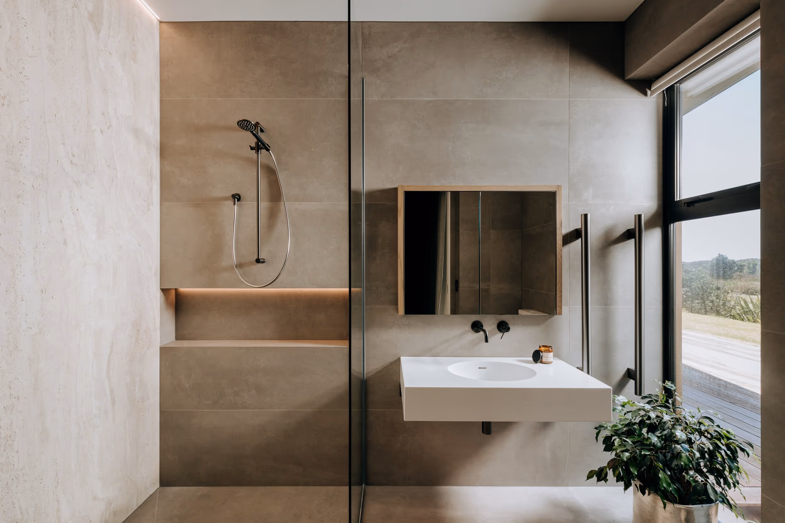 Modern bathroom with floating white sink and beige marble walls. 