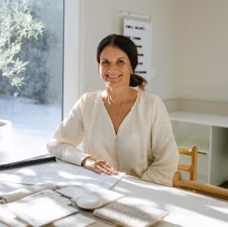 Woman standing behind desk looking at interior samples.