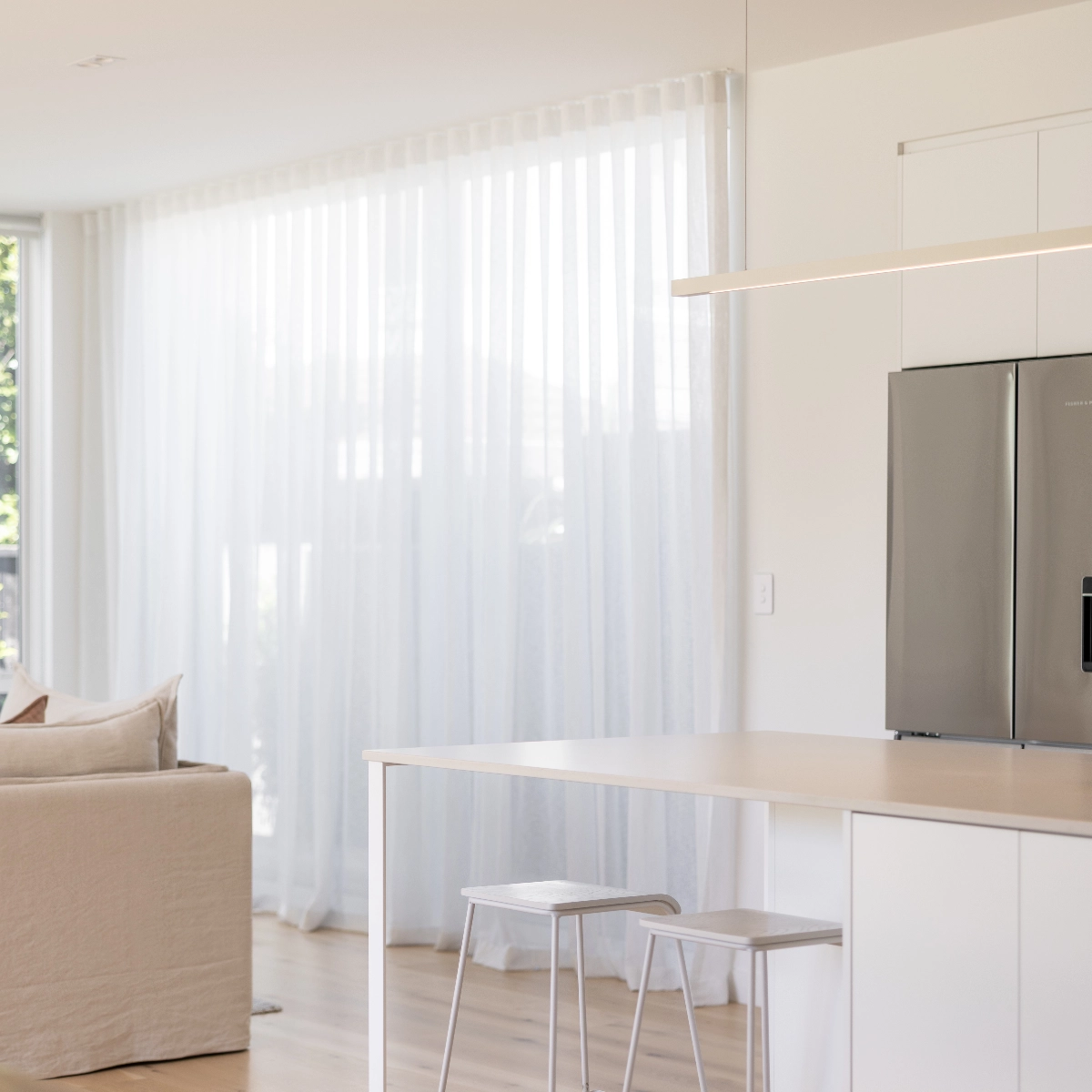 White curtains hanging in the kitchen.