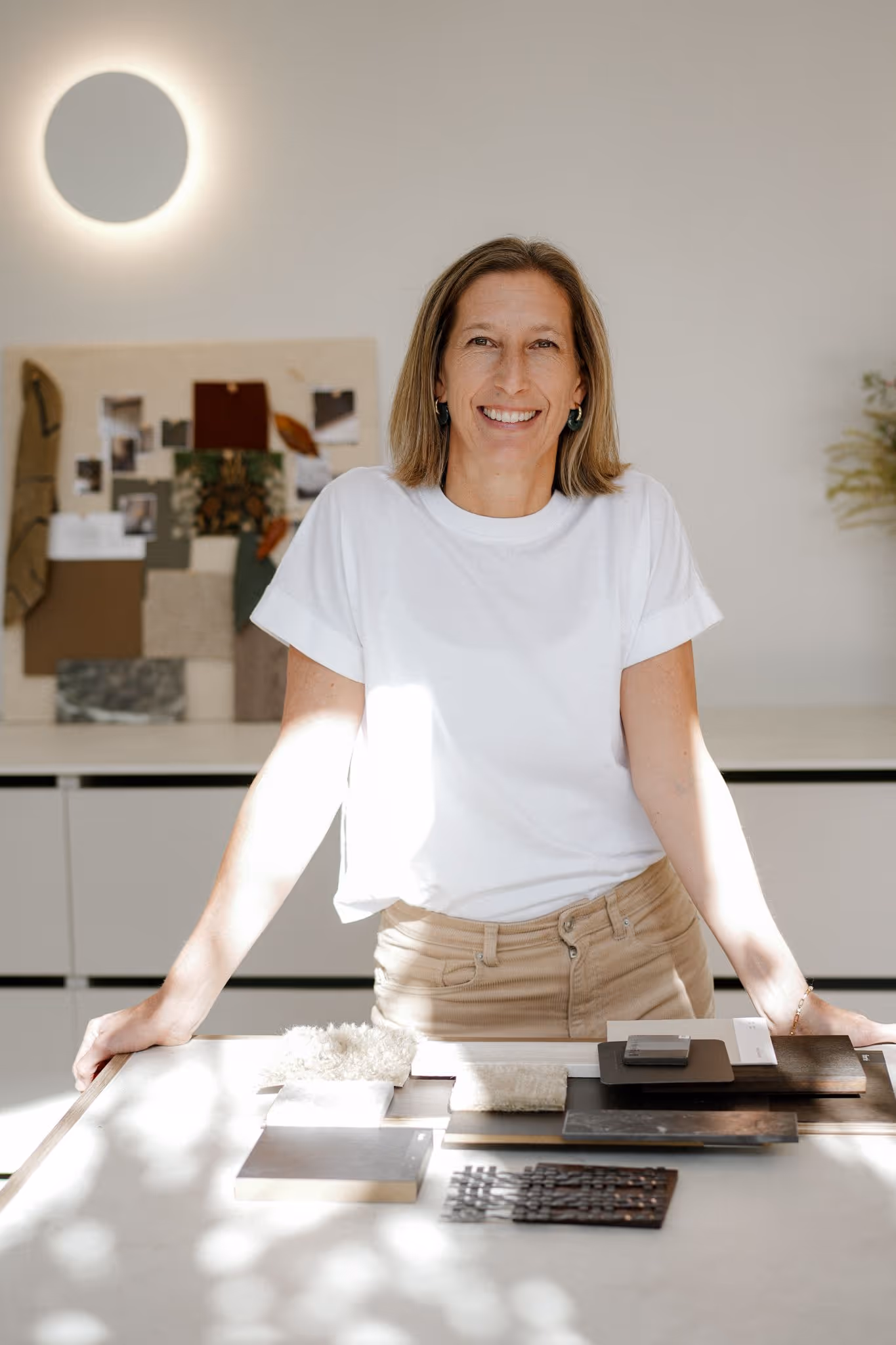 Woman standing behind desk with white t-shirt.