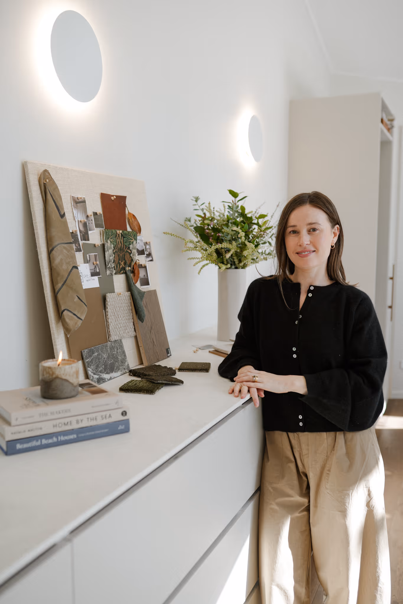Woman standing next to samples of carpet.