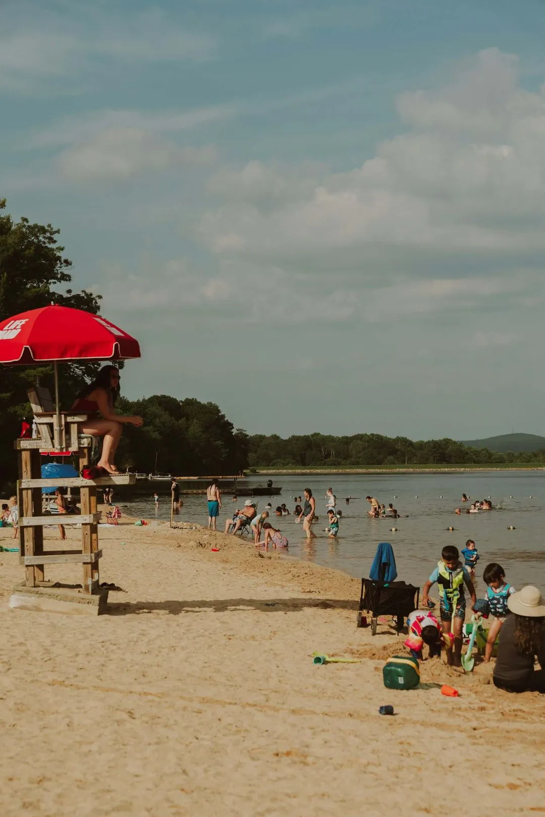 a lifeguard at the beach looking over people at a lake