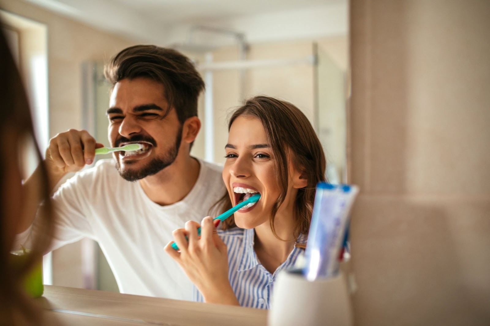 Couple brushing their teeth together practising daily oral hygiene between dental visits in Essex