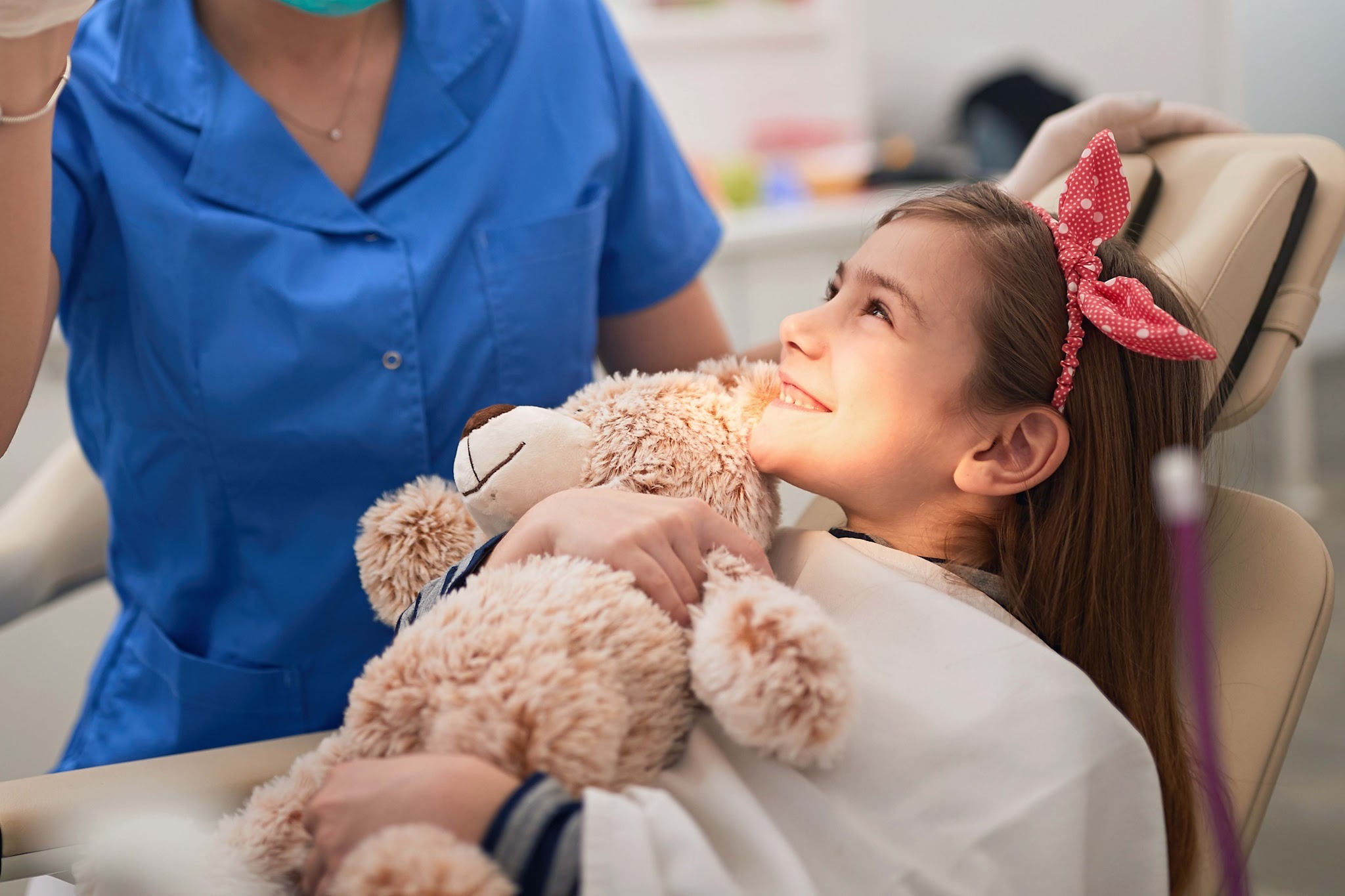 Child patient at a dental appointment in Upminster holding a teddy for comfort during treatment
