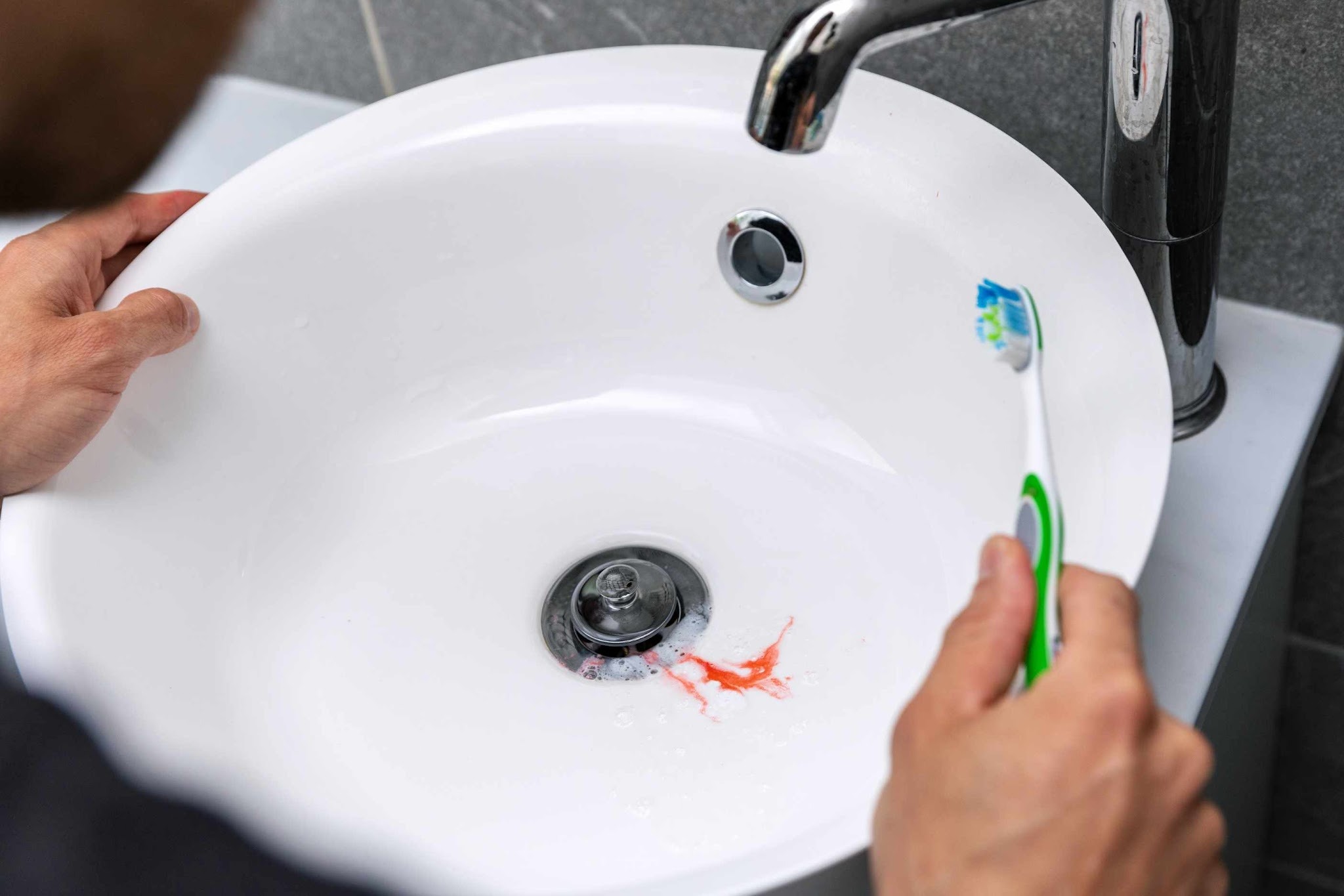 Blood in sink after brushing teeth caused by bleeding gums and possible gum disease