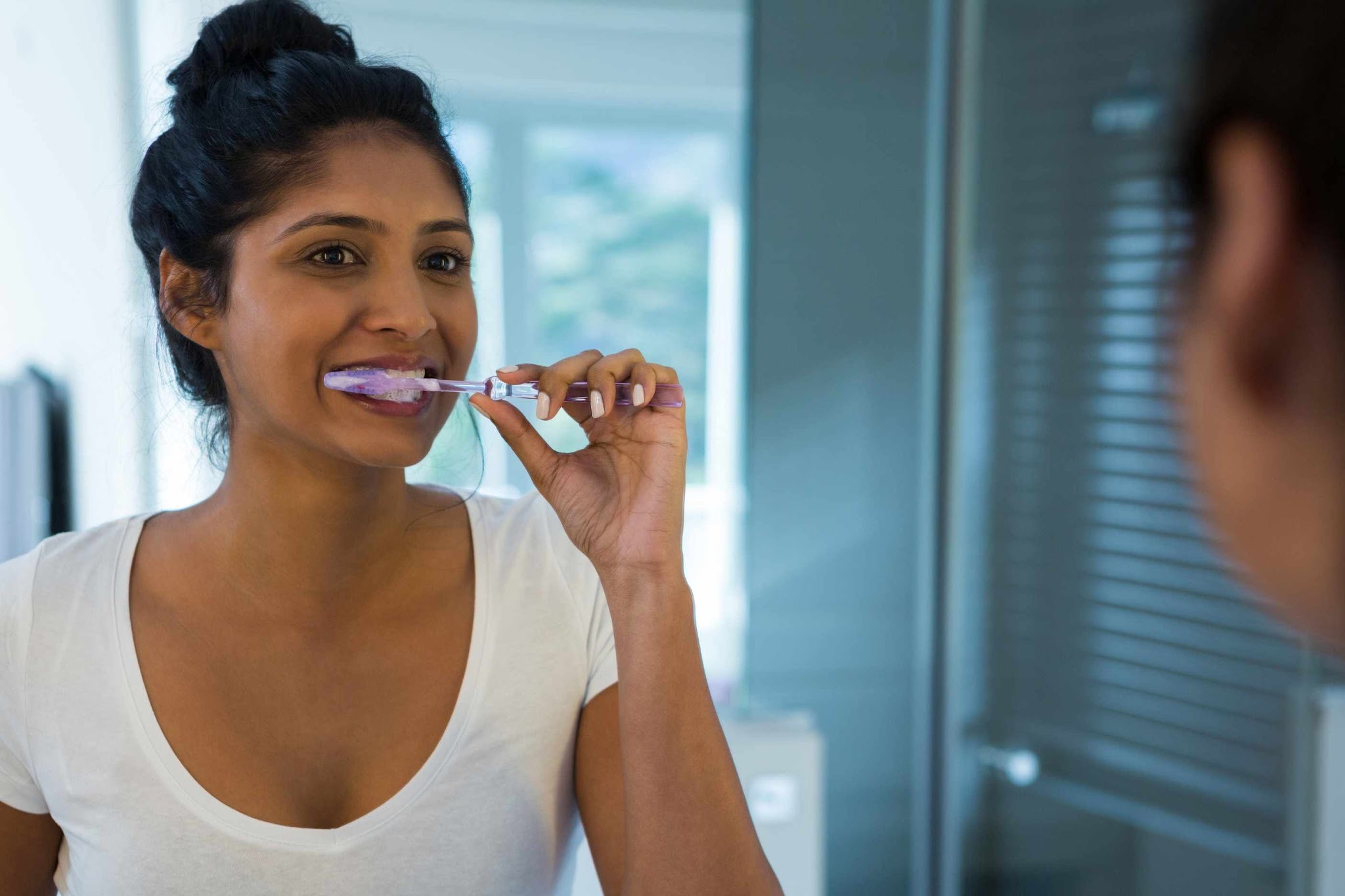 Patient brushing teeth to maintain healthy gums and reduce the risk of gum disease