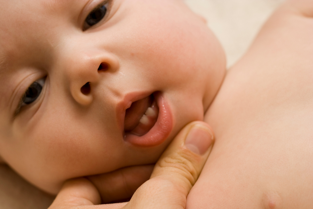 Baby with first milk tooth during an early dental care stage