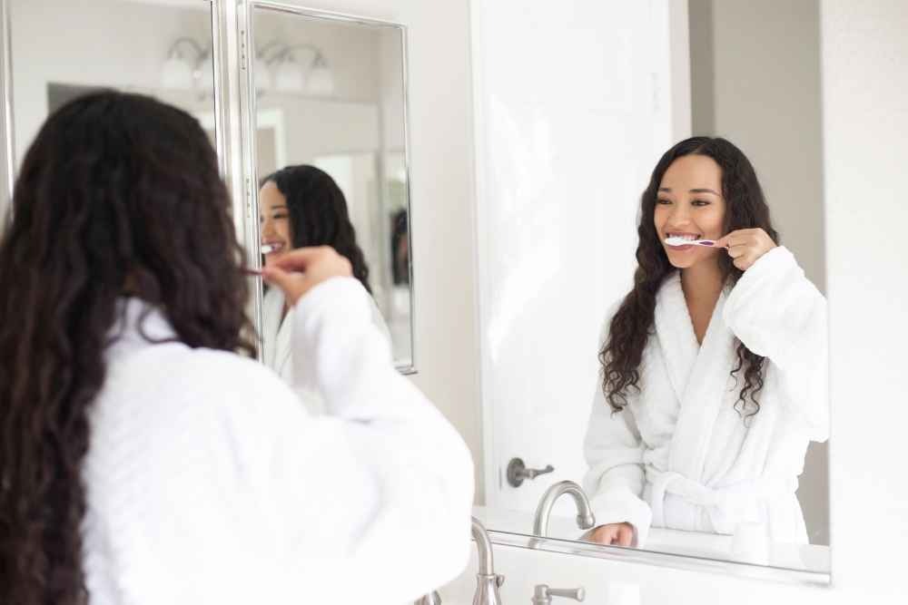 Woman brushing her teeth as part of her daily oral hygiene routine
