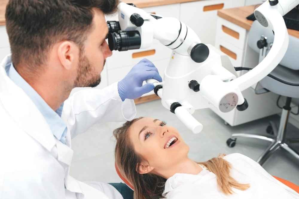 Dentist using an operating microscope during dental treatment