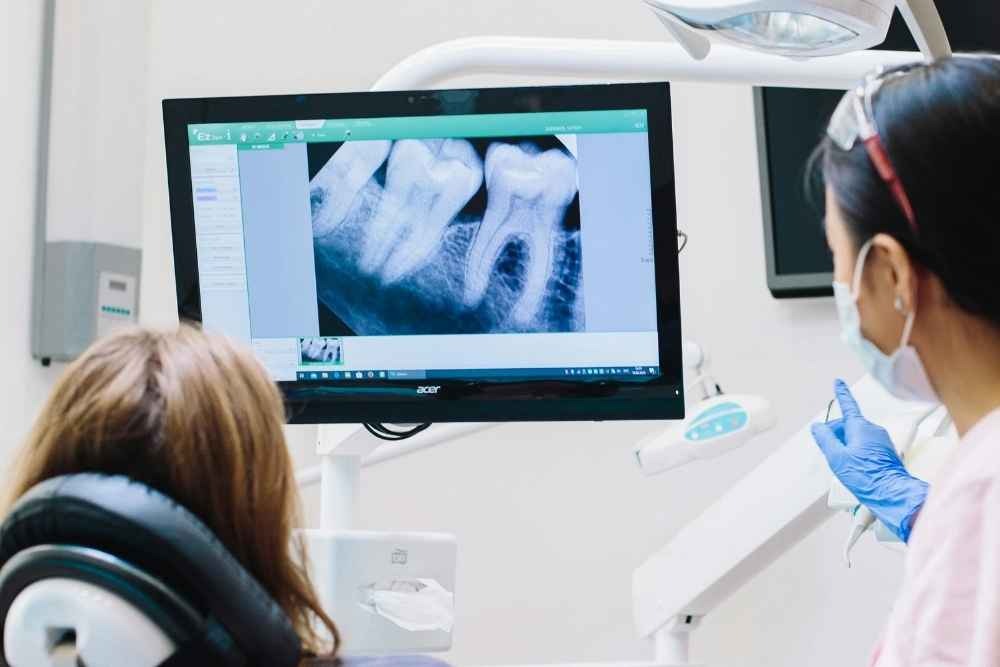 Dentist reviewing a dental X-ray showing the roots of a tooth