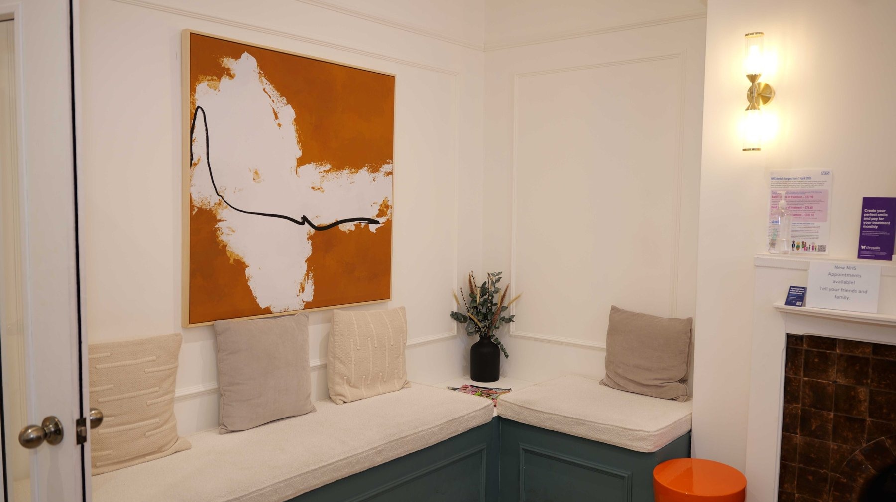 The bright waiting area at Church View Dental, with cushioned seating and orange artwork