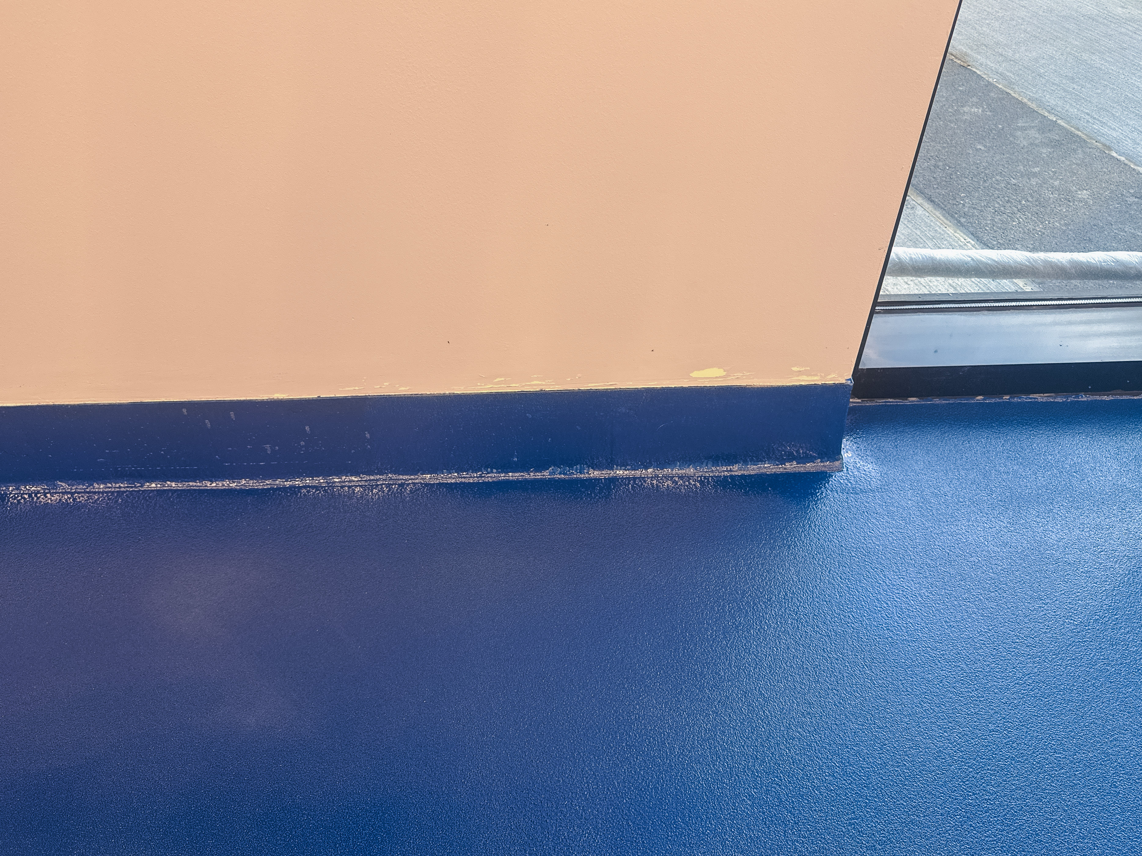 Close-up of pigmented epoxy floor coating in MTSU blue with smooth, seamless high-gloss finish.