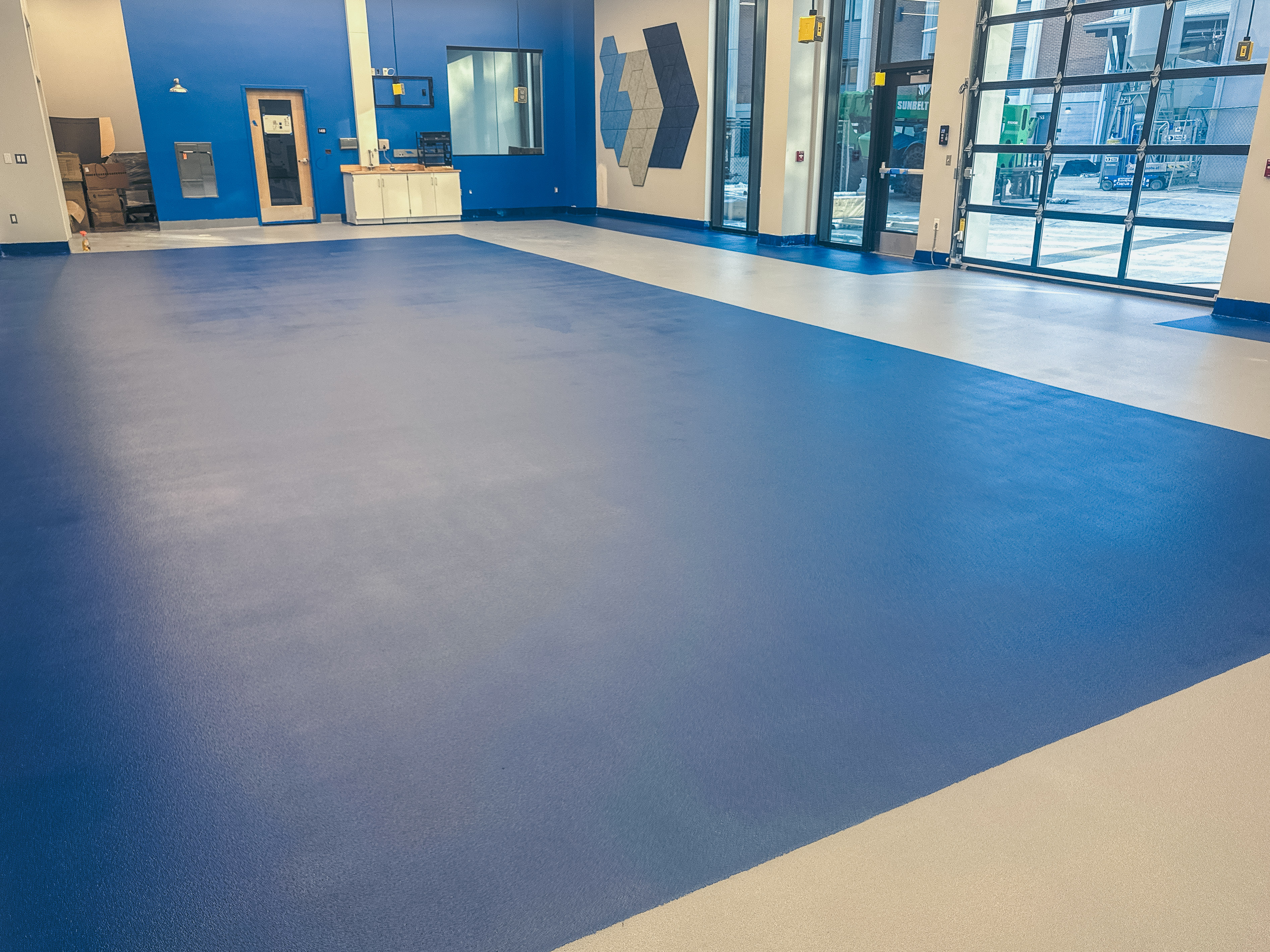 Light reflecting off seamless high-gloss epoxy floor installed in university engineering building.