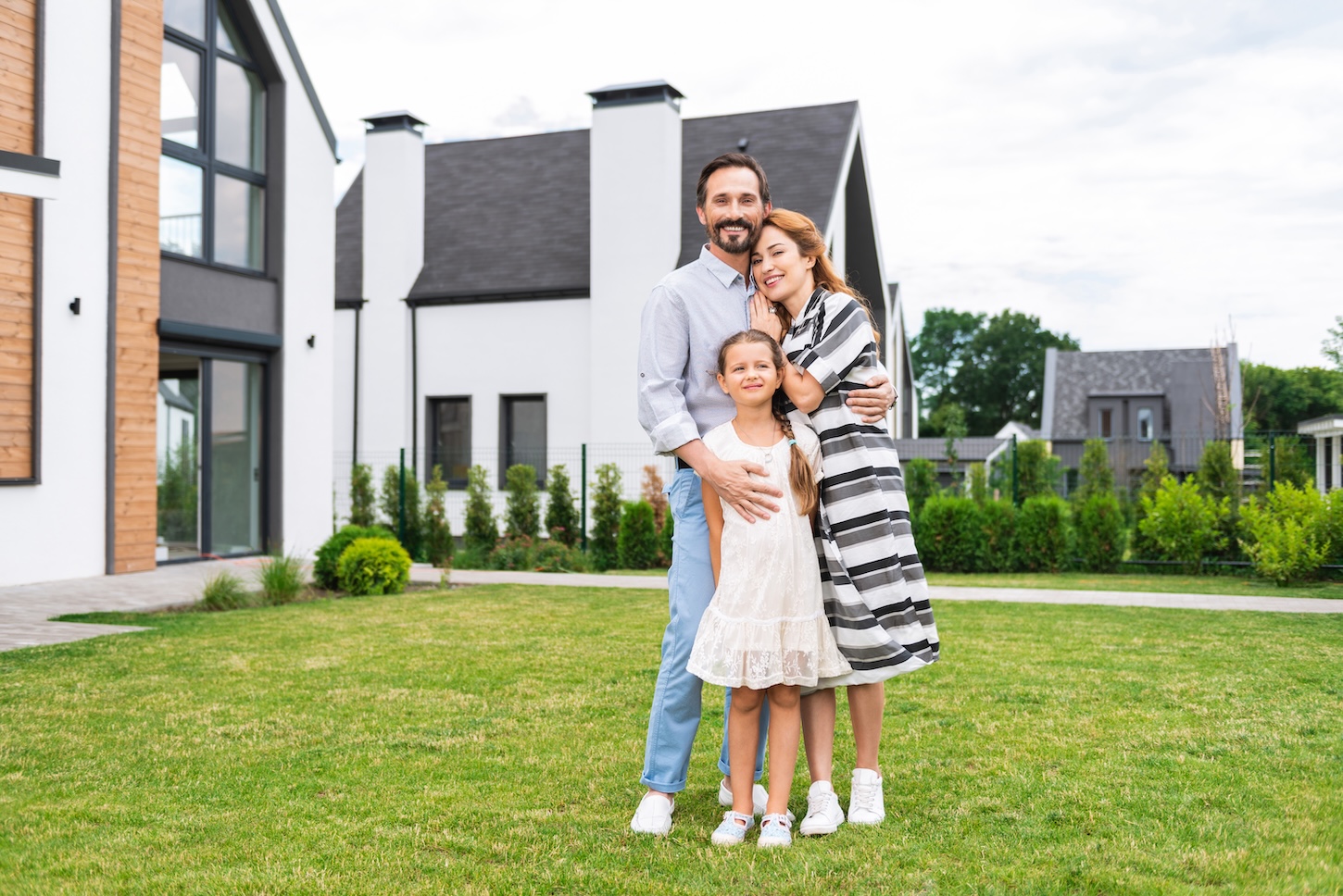 A family standing in front of their brand new home