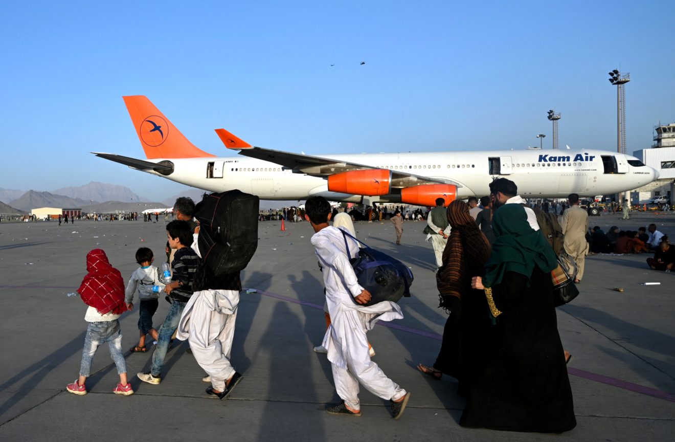 Kam Air plane with people walking on tarmac in Afghanistan