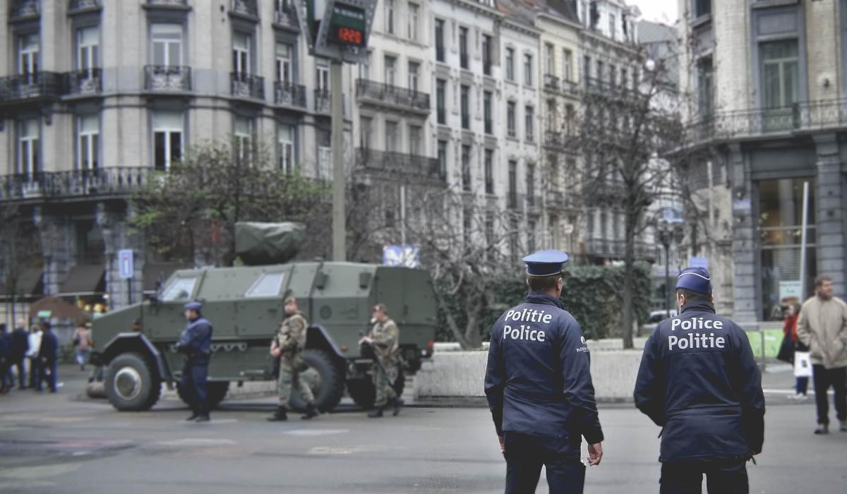 Police officers and military vehicle on street in urban European setting