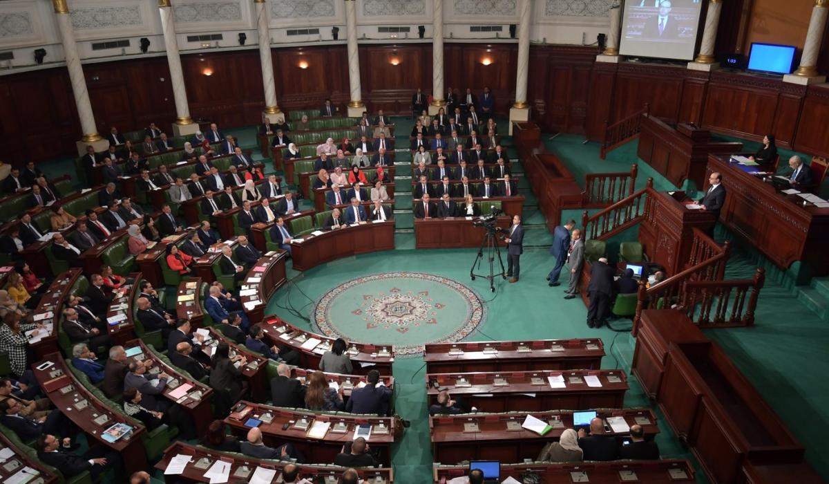 Crowded legislative chamber with green seats during parliamentary session