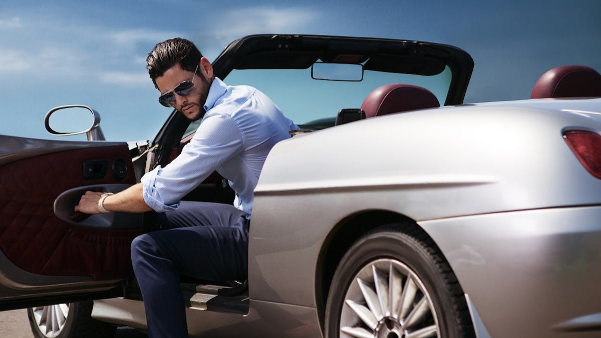 Automobiliste conduisant une voiture luxueuse