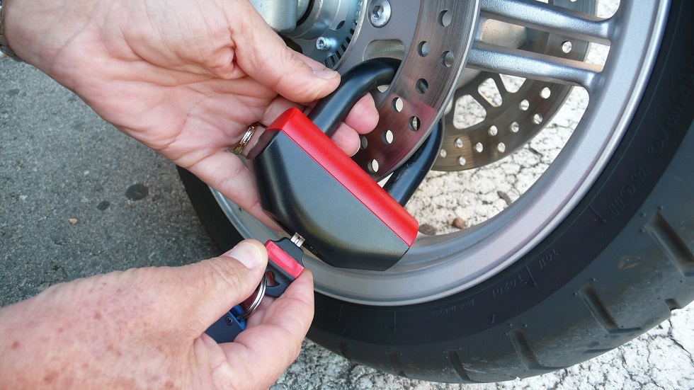 Motard installant antivol moto