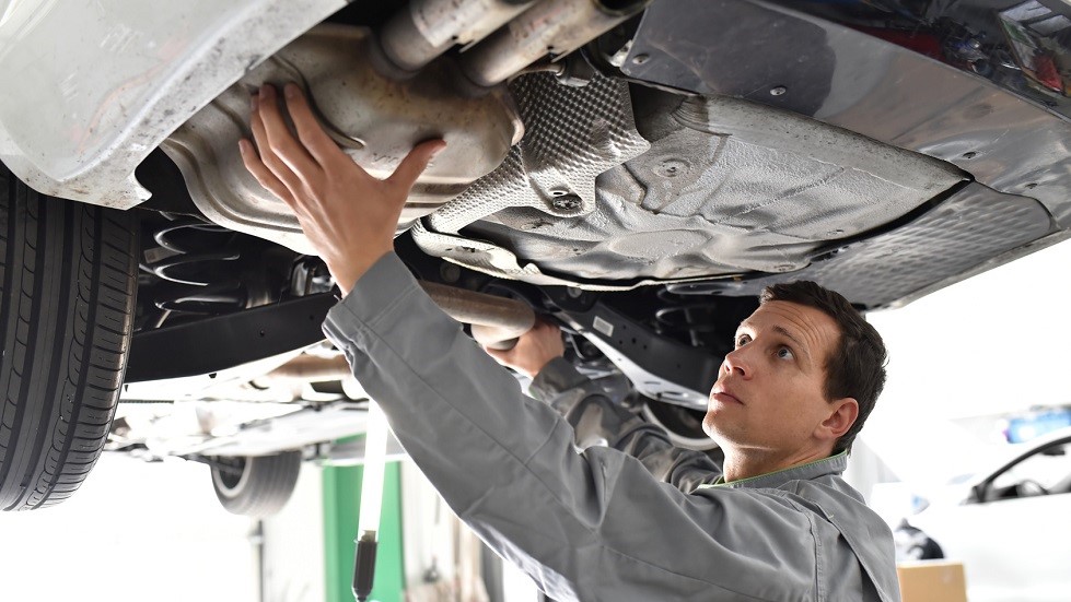 Garagiste reparant echappement voiture