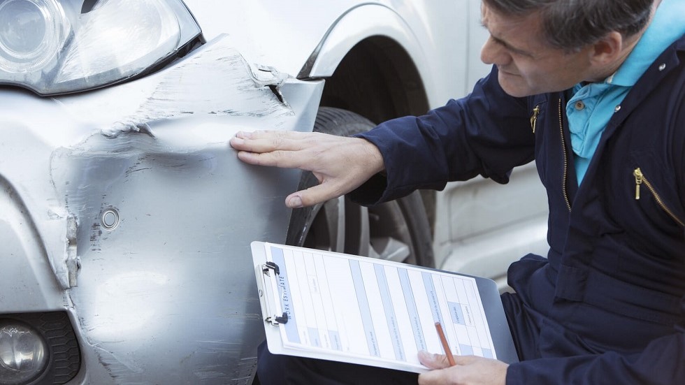 Expert inspectant un vehicule accidente