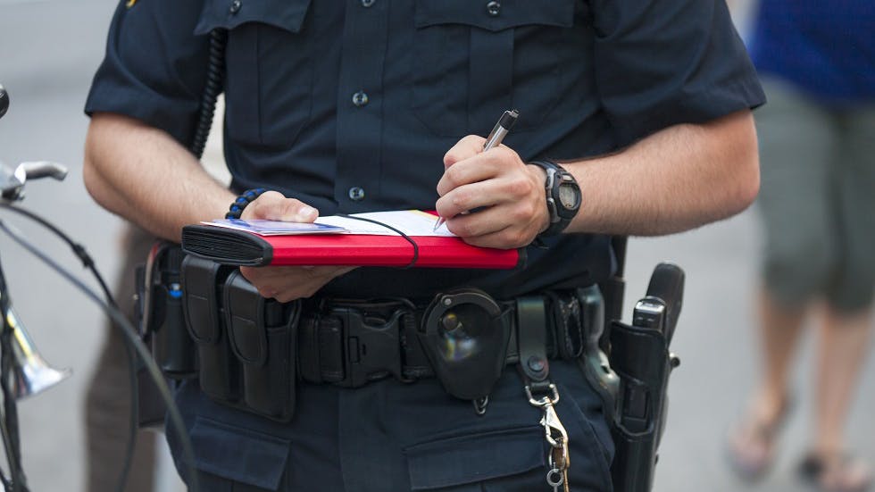 Policier remplissant une contravention sur son carnet