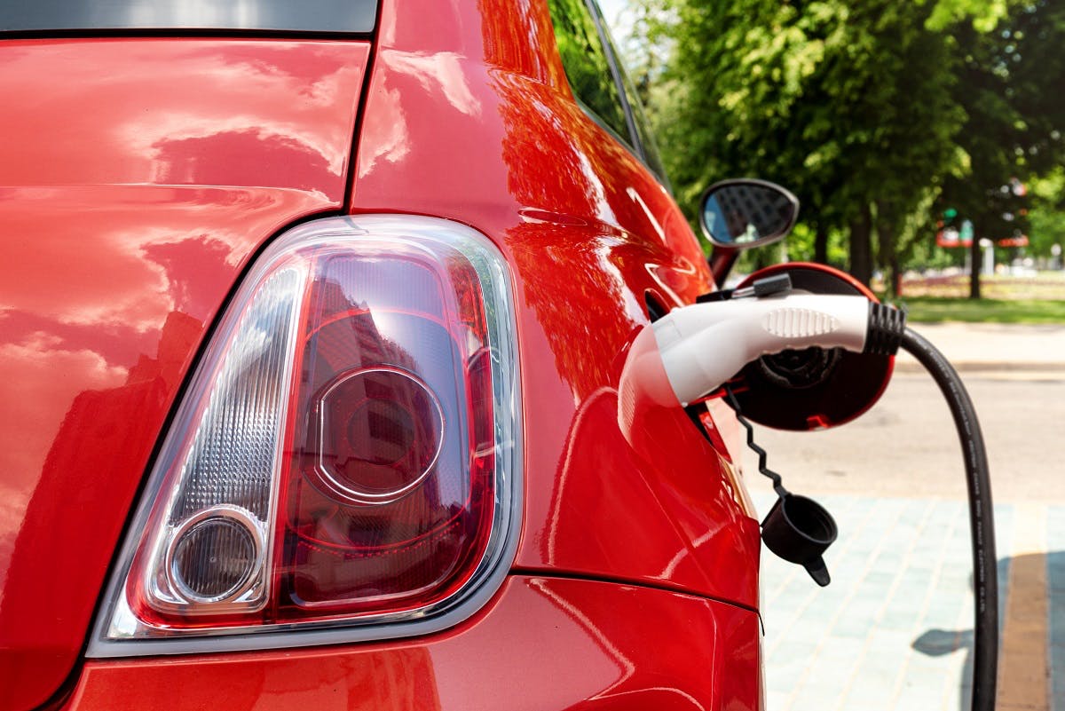 Voiture electrique rouge en recharge