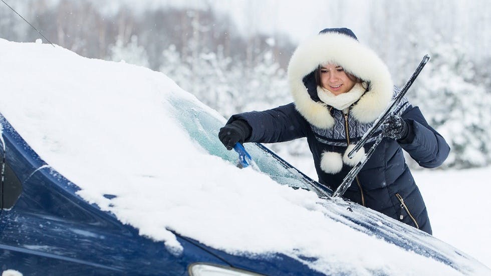 Conductrice degivreant son pare-brise