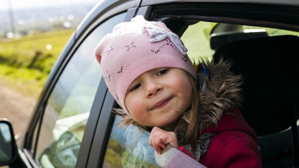 Fillette passant sa tete par la fenetre d une voiture