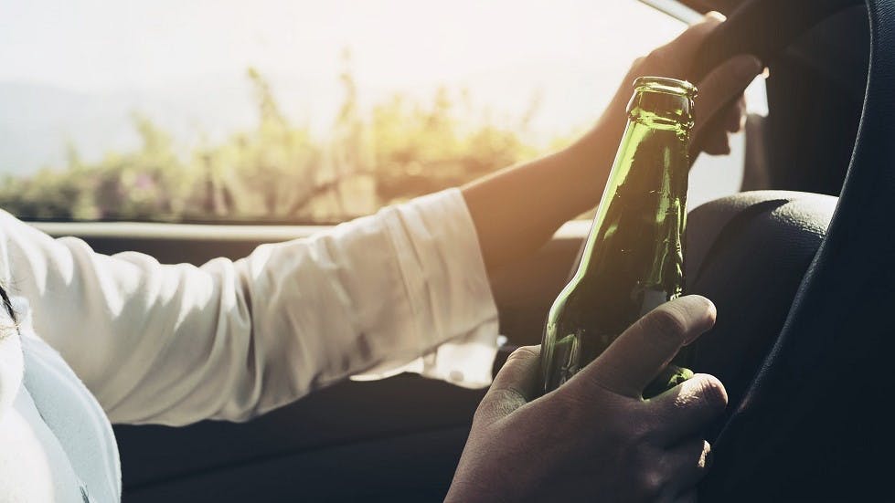 Conductrice consommant de la biere au volant