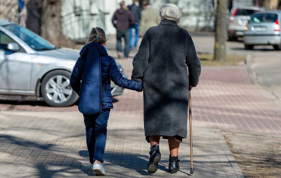 Senior et enfant traversant rue