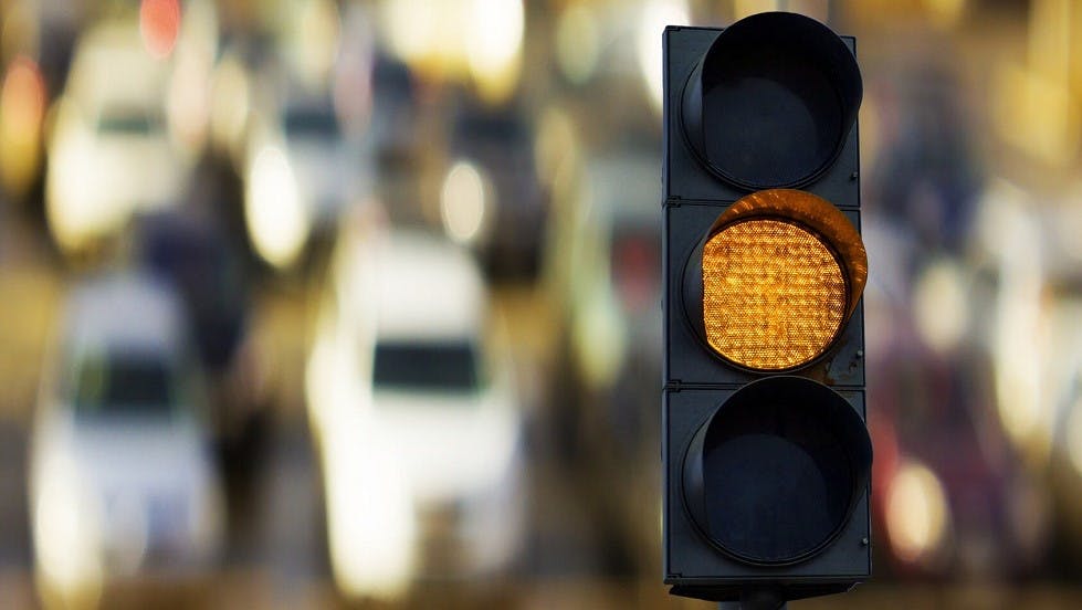 Feu de signalisation orange devant un parking