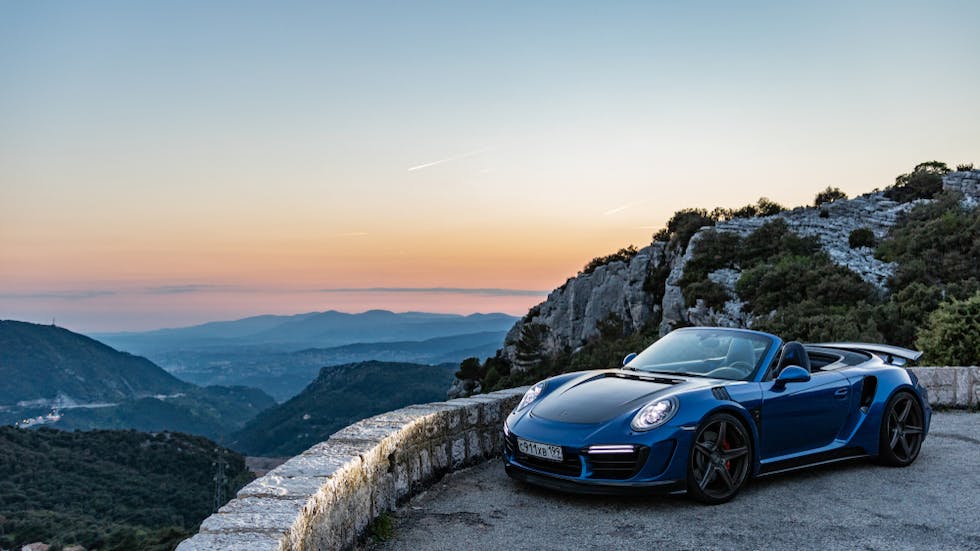 Voiture coupe cabriolet devant des montagnes