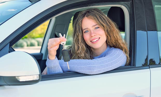 Jeune fille heureuse d'avoir les clés de sa voiture grâce à son permis chez Ornikar