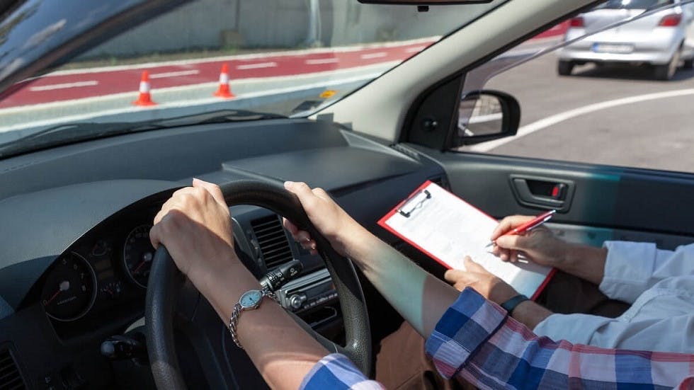 Examinateur notant une candidate a l'examen du permis de conduire