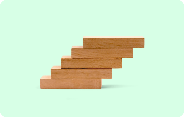 Five wooden blocks stacked in a stair-step pattern against a light green background.