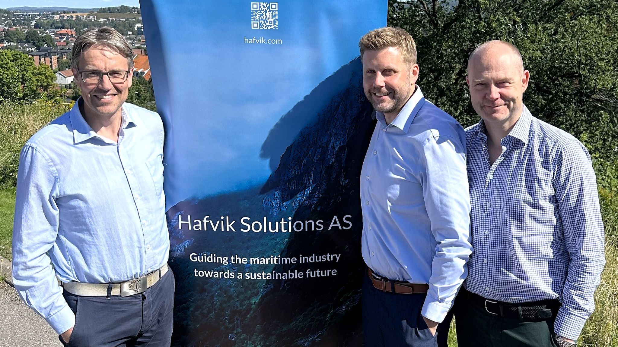 Øystein Skår, Niclas Moen og Thorbjørn Hareide foran seil med logoen til Hafvik Solutions