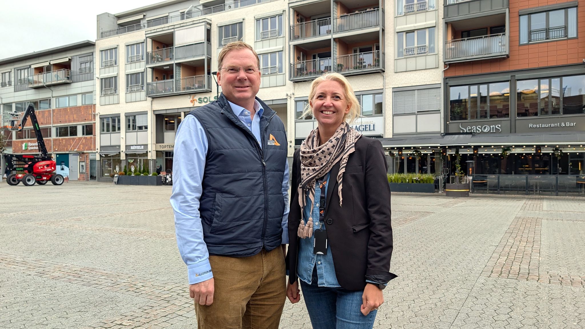 Rolf Th. Holm og Charlotte S. Bergerud foran en rekke med bygg på Lillestrøm Torv