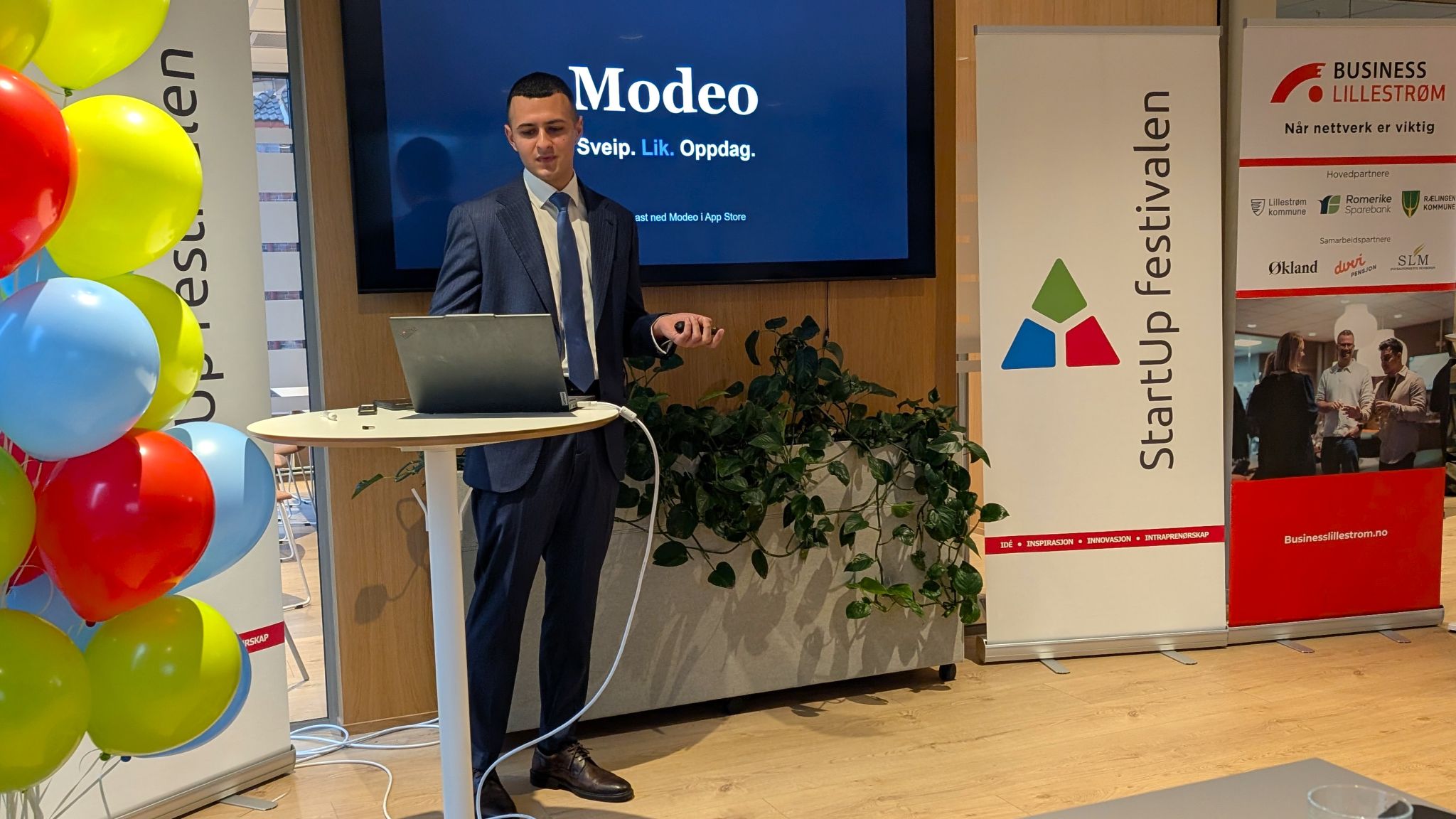 Aland Azdin presenterer forretingsideen sin på scenen