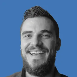 A man with a beard and mustache smiling for the camera.