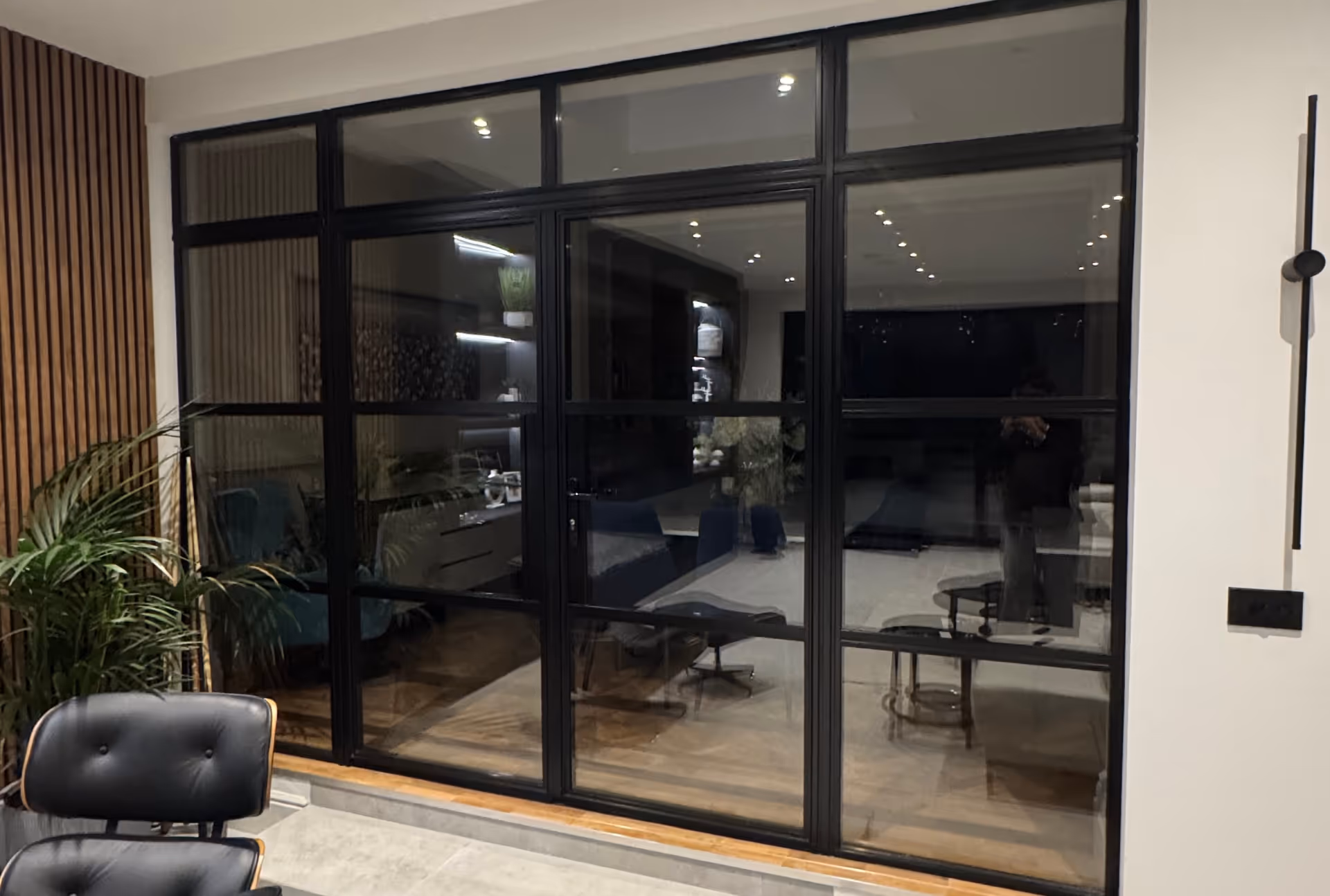 Black heritage-style door with grid glass panes in a modern interior setting.