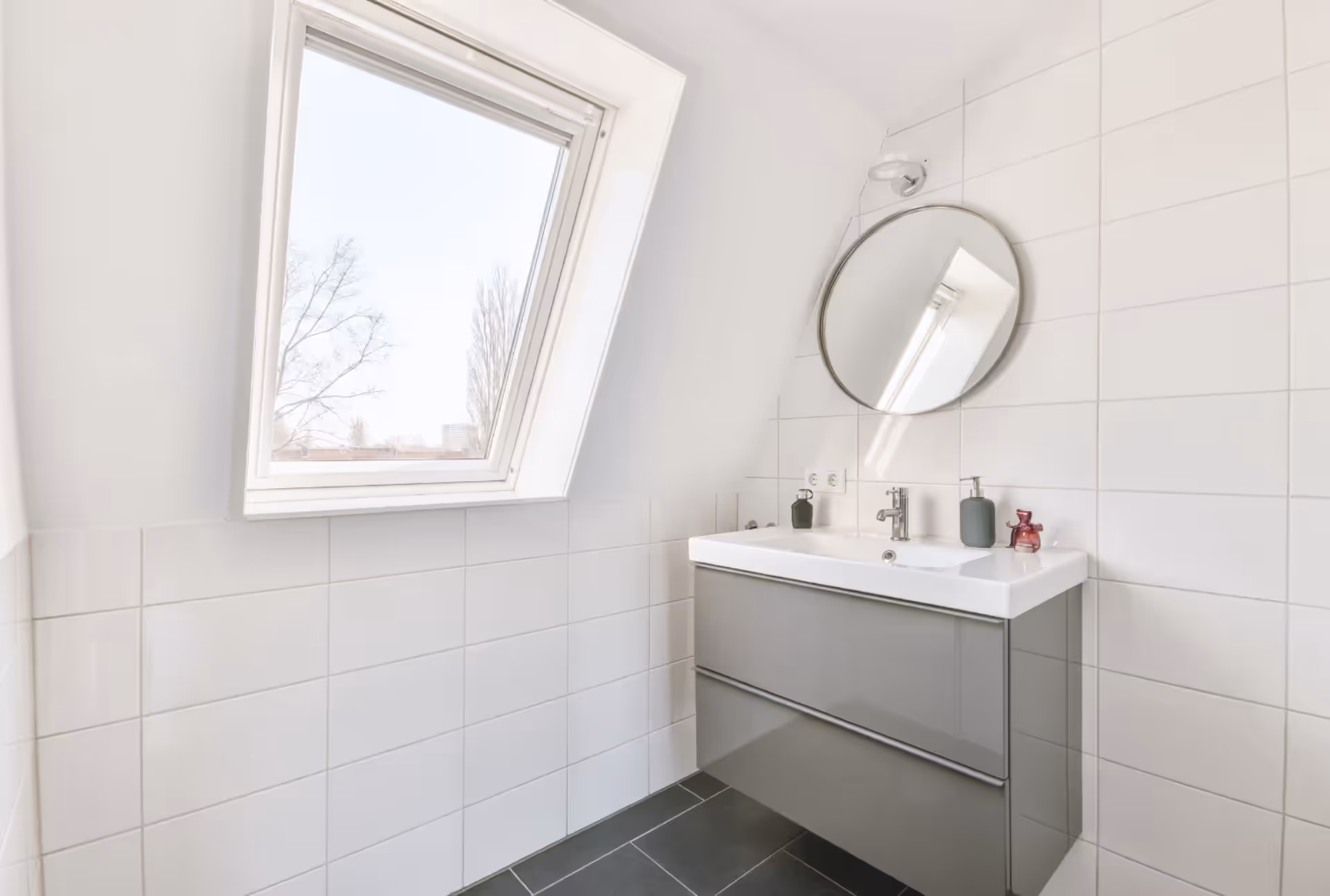 Bathroom window opening outward from the bottom, positioned high for privacy while allowing light and airflow.