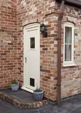 Stylish brick facade with cream UPVC door and side window by premium window and door suppliers