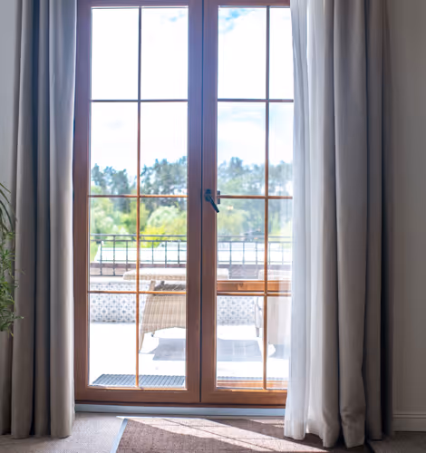 Tall four-pane window overlooking a lush garden